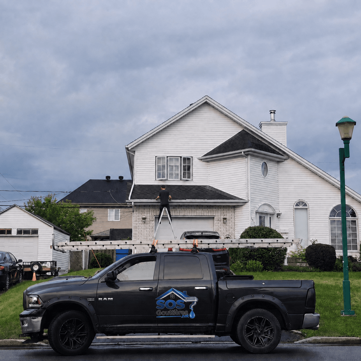 Technicien nettoyant les gouttières d'une maison à Laval